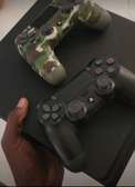 PlayStation 4 noire avec 2 manettes dont camouflage