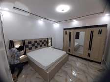 Chambre à coucher bois foncé lit armoire commode éclairage