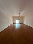 Salon spacieux parquet clair avec balcon lumineux