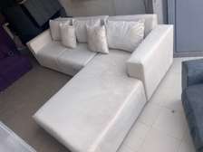 Canapé d'angle beige clair 5-6 places avec pouf rouge