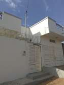 Maison moderne blanche avec portail sécurisé et barbelés