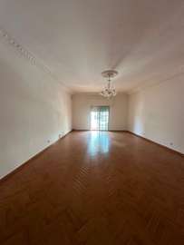 Salon spacieux parquet clair avec balcon lumineux