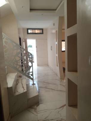 Maison moderne blanche avec portail sécurisé et barbelés image 3