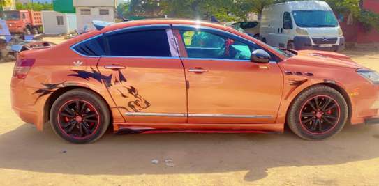 Berline sport orange métallisé jantes noires liseré rouge image 2