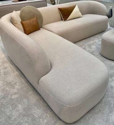 Canapé d'angle blanc cassé avec pouf orange design image 3