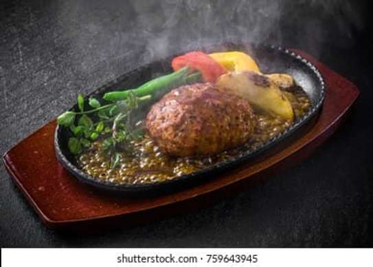 Cast iron hot sizzling plate on wooden tray image 3