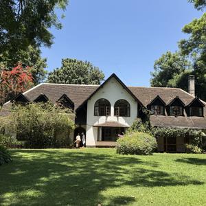 Serengeti Manor – Thigiri, Nairobi

Location: Thigiri, Nairobi
Land: 2 acres of beautifully landscaped grounds, offering privacy and seclusion.

A Rare Opportunity to Rent a Gabled Manor of Distinction:-
Welcome to Serengeti Manor, a characterful and storied estate unlike any other â€” a rare opportunity to make your home in a lovingly built manor house designed by a passionate Italian settlor with a flair for life, beauty, and timeless architecture. This elegant gabled residence stands proudly on two acres of flat, mature gardens and comes complete with a swimming pool, tennis court, and private guest cottage.

This is more than a home; it's a place where memories are made and legacies lived.

A Sanctuary of Charm and Elegance
From the moment you arrive, Serengeti Manor enchants. A red-brick herringbone driveway winds beneath the graceful arms of an umbrella tree, offering shade for your arrival and a whimsical playground for little ones. Ahead, the gabled home rises â€” its presence both grand and welcoming, framed by manicured lawns and expansive greenery that beckons you to pause and breathe.

Refined Interiors for Inspired Living
Step inside to traditional terracotta tiles and polished wooden floors, all beneath soaring double-height ceilings. The entrance hall offers an immediate sense of grandeur and intimacy â€” leading you to a series of beautifully appointed living spaces.

To your right, an elegant sitting room with a fireplace and built-in bar spills onto a wide, covered veranda â€” an ideal setting for al fresco entertaining beneath the African sky. A formal dining room with garden views promises long evenings of laughter and shared stories, while a second cosy lounge invites relaxed mornings with coffee or a good book.

The expansive kitchen, fitted with two generous pantries and a breakfast area, is a culinary haven for the home chef or host alike.

Private Wings & Thoughtful Design
Upstairs, the home divides into two serene wings. The children's wing offers a three-room suite, perfect for sleep, play, study â€” or all three.

The parents' wing is a sanctuary in itself, featuring a grand master bedroom with vaulted ceilings, dual bathrooms (his and hers), a dedicated dressing room, and serene views on both sides. A versatile adjoining room can serve as a nursery, reading lounge, or private retreat. The entire wing is secured with a discreet security door for peace of mind.

In total, the manor boasts seven elegant gables  a testament to its architectural pedigree.

Charming Guest Cottage
Tucked just behind the main home lies a two-bedroom ensuite guest cottage with its own living and dining room and a sun-dappled courtyard shaded by a young tree â€” perfect for morning coffee or a restful afternoon read. Upstairs, a cosy landing joins the two bedrooms, offering privacy and charm for guests or extended family.

Exceptional Outdoor Living
The estate grounds are a celebration of nature and leisure. Mature gardens stretch across two flat acres, alive with birdsong and blooming colour. The swimming pool and tennis court offer idyllic afternoons outdoors.

Every detail at Serengeti Manor has been thoughtfully curated â€” from the gables that catch the morning light to the warmth of wood underfoot and the breeze whispering through the trees. This is not just a home â€” it's a celebration of life, heritage, and style.

Amenities
- 4+ Bedrooms (Main House)
- 2-Bed Guest Cottage
- Seven Elegant Gables
- Double-Height Ceilings
- Fireplace
- Built-in Bar
- Swimming Pool
- Tennis Court
- Massage Room
- Covered Veranda
- Grand Powder Room & Cloak Room
- 2 Generous Pantries
- Terracotta & Wood Floors
- 2 Covered Garages
- 4 Staff Quarters
- 2 Acres Mature Gardens

Location & Neighbourhood
Thigiri remains one of Nairobi's benchmark residential neighbourhoods, known for large plots, mature landscaping, and longstanding prestige. Serengeti Manor makes the most of that setting, offering estate-scale living within convenient reach of schools, clubs, shopping, and diplomatic routes â€” and within walking distance of Village Market.

Main Property

The brochure presents Serengeti Manor as a spacious, private residence surrounded by:

Mature indigenous trees
Manicured lawns
Established gardens
Extensive landscaped grounds
Private leisure amenities
Guest Cottage

A 2-bedroom ensuite guest cottage is located behind the main home. It includes:

Two ensuite bedrooms
Living room
Dining room
Petite kitchen
Private courtyard
Upstairs landing connecting the bedrooms

The cottage is suitable for guests or extended family.

Amenities
🔥 Fireplace
🍸 Built-in bar
🎾 Tennis court
🏊 Swimming pool
🍳 Newly refurbished kitchen
🚿 Newly refurbished bathrooms
🪵 Terracotta & wood floors
🌳 Mature gardens

Lifestyle

The property is positioned as a peaceful private sanctuary surrounded by manicured gardens and mature indigenous trees, designed particularly for couples and single living.

Rent to be paid in USD 3,000.00 per month 

( The property is available from the 1st of September 2026)